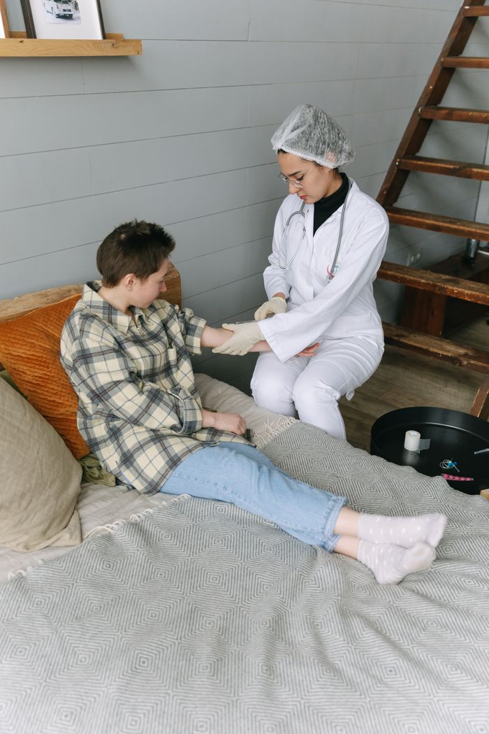 Services Healthcare worker assisting a patient in a home setting, providing care and support.